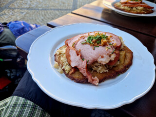 a dialect term for a potato pancake, in almost all of Bohemia. It is served with sauerkraut and smoked pork in the shape of a pocket