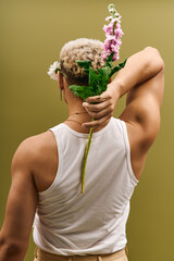 Captivating young man with dyed hair and flowers poses stylishly in a studio setting