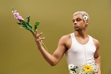 Young man showcases floral elegance in trendy studio setting