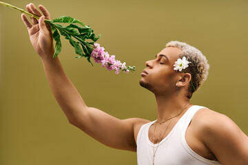 Young man embracing floral beauty in stylish studio setting