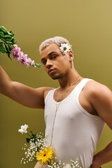Young man showcasing floral beauty and modern fashion in a trendy studio setting