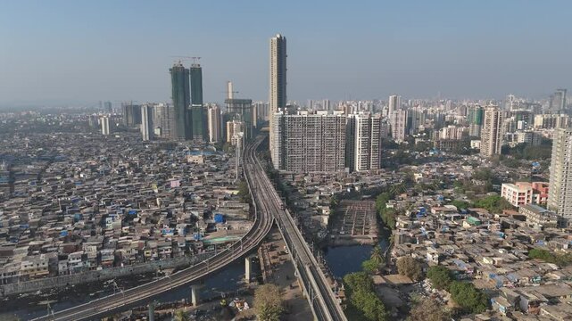 Aerial view of Mumbai cityscape with metro train, India.