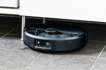 Robot vacuum cleaner with dust, real life photo, saves time and goes into hard-to-reach places