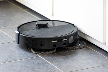 Robot vacuum cleaner with dust, real life photo, saves time and goes into hard-to-reach places