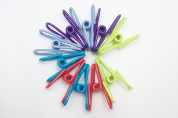 Colorful Clothespins in Circular Pattern on White Background. A vibrant top-down image of colorful...