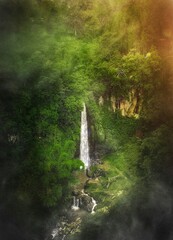 Scenery of aerial Fresh Flow of waterfall from natural spring in the middle of the green lush nature forest