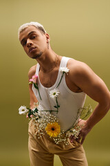 Young man showcasing fashion style with dyed hair and flowers in modern studio setting