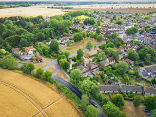 Large English village in rural Essex en surrounded by drought ridden arable fields in summer. A parched village green can be seen near the centre of the photograph.