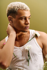 Young man showcases trendy style in a floral-themed fashion studio session