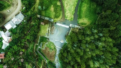 Beautiful view of aerial Fresh Flow of water from natural spring in the middle of the green lush nature forest