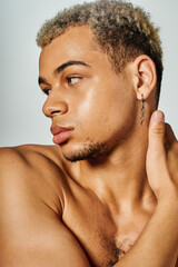 Young african american man with dyed hair showcases beauty in studio setting