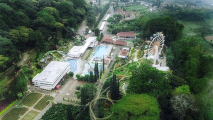 Beautiful aerial view of the Ferris wheel and playground in the middle of lush green natural park