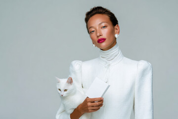 Fashion model posing with white kitten and blank card