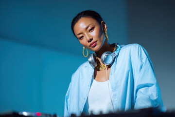 Confident female dj mixing music at event