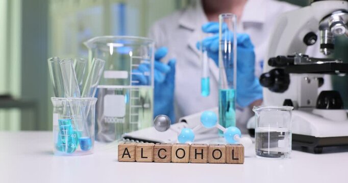 A scientist conducts experiments with various alcohol types in a lab, using specialized equipment for analysis