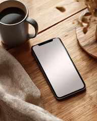 Modern smartphone lying on desk with sunlight. Scene includes flat-edged smartphone, soft cloth, and hot drink arranged aesthetically on wooden texture.