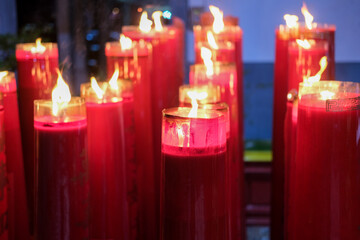 Giant red candles glow brightly in a temple during Chinese New Year and Cap Go Meh celebrations, symbolizing hope and prosperity.