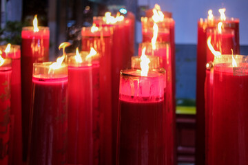Giant red candles glow brightly in a temple during Chinese New Year and Cap Go Meh celebrations, symbolizing hope and prosperity.