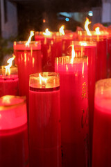 Giant red candles glow brightly in a temple during Chinese New Year and Cap Go Meh celebrations, symbolizing hope and prosperity.