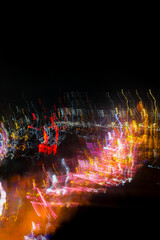 Vibrant light trails in motion blur form dynamic patterns across a dark background, creating an...