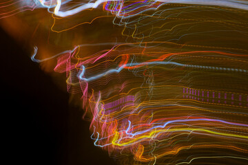 Colorful abstract light trails create a mesmerizing motion effect against a dark background,...