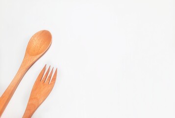 A wooden spoon and fork isolated on white background. There is a space to text.