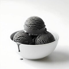 Black ice cream scoops in white bowl on white background