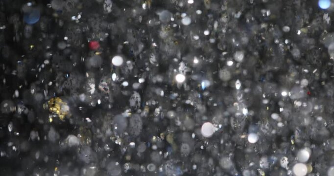 Spellbound silver confetti flies at festive party creating magical atmosphere. Sparkling festive ornament with shimmer shower at holiday celebration