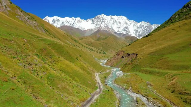 Majestic Caucasus Mountains scenic valley river road green hills snow peak adventure travel landscape photography nature beauty Georgia Ushba