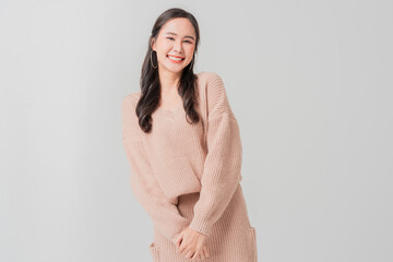 Studio portrait shot of positive Asian woman in casual sweater dress making warm welcome hand...