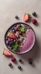 A vibrant smoothie bowl topped with fresh strawberries, blueberries, blackberries, raspberries, and...