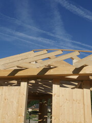 A wooden structure with a slanted roof is being built