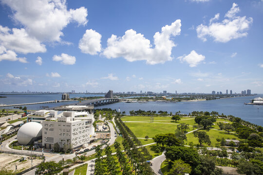 Aerial view of the vibrant green lawn of the park meeting the waters of Biscayne Bay near the Perez Art Museum and the MacArthur Causeway, Miami, Florida, United States.