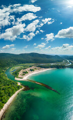 Aerial view of the picturesque curves of a river among lush vegetation that flows into the sea,...
