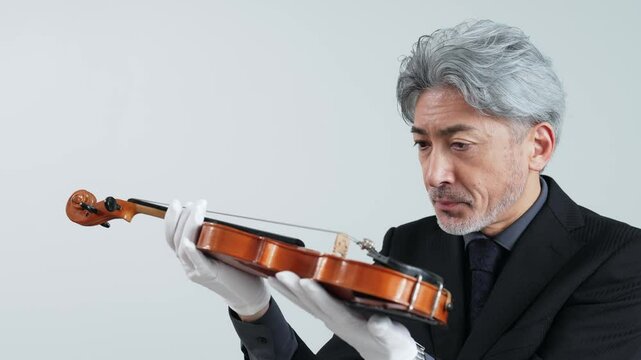 バイオリンを確認するミドルエイジ男性