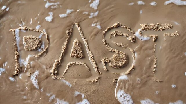 Top view pf a gentle ocean wave  washes away the word PAST handwritten on the sand of a beach, concept for nostalgia, letting go and moving forward with life
