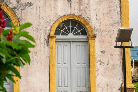 Pale gray door capped by a semicircular fanlight nestles.