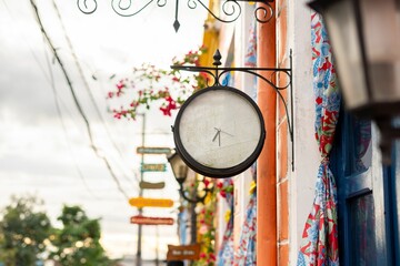 Street scene with a vintage clock on a colorful building facade.