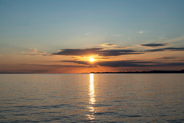 red and orange sunset over Lake Constance and the island of Lindau in Germany with beautiful clouds seen from the Austrian coastline in Bregenz 