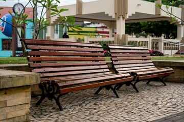 Wooden benches in a park with modern architecture.