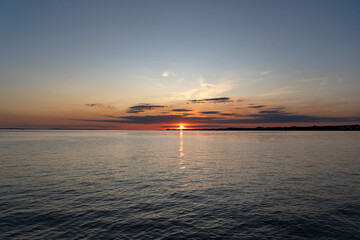 Naklejka premium red and orange sunset over Lake Constance and the island of Lindau in Germany with beautiful clouds seen from the Austrian coastline in Bregenz 