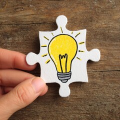 Hand holds a puzzle piece with a lightbulb drawing