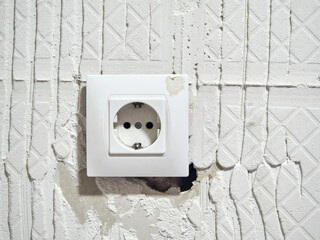 socket in a plasterboard wall where the tiles have been removed