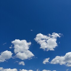 partly cloudy clear blue sky covered with small white clouds