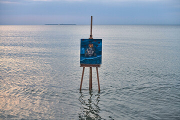 Easel with striking abstract painting stands in calm ocean waters, creating surreal ambiance. Scene...
