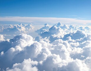 Expansive view of fluffy white clouds against a bright blue sky, creating a serene atmosphere, showcasing the beauty of nature and the vastness of the sky above