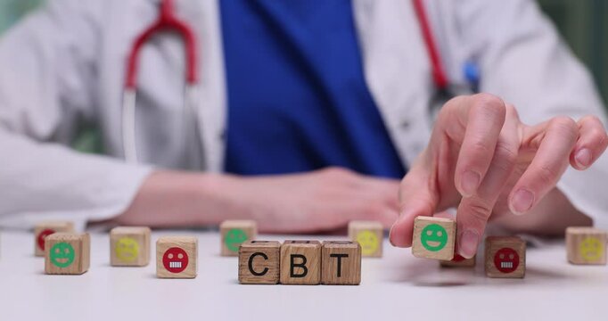 A qualified professional showcasing the principles of Cognitive Behavioral Therapy using wooden blocks in practice