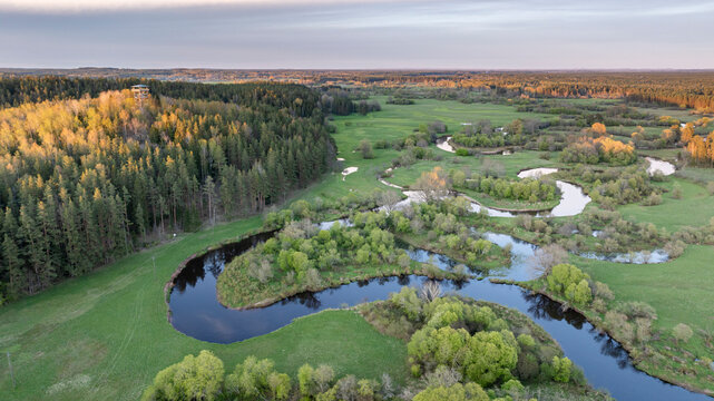 Aerial view to the sunset colored spring landscape of the Mustj&otilde;gi river valley, oxbows and meadows and public watchtower in Tellingum&auml;e, Tsirgum&auml;e k&uuml;la, Valga vald, Valgamaa