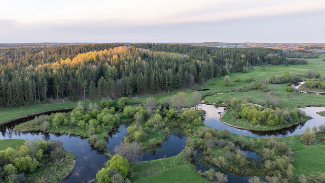 Aerial view to the sunset colored spring landscape of the Mustj&otilde;gi river valley, oxbows and meadows and public watchtower in Tellingum&auml;e, Tsirgum&auml;e k&uuml;la, Valga vald, Valgamaa