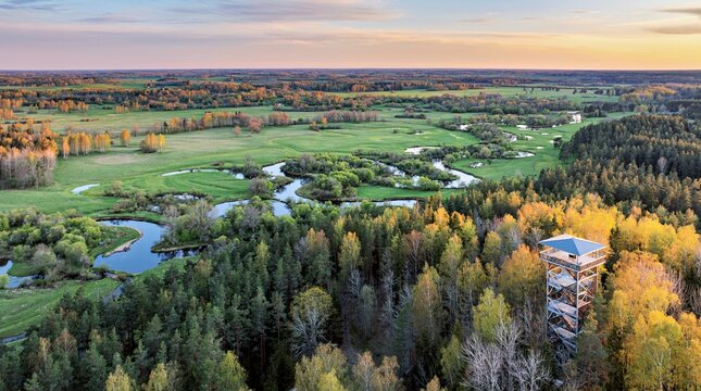 Aerial view to the sunset colored spring landscape of the Mustj&otilde;gi river valley, oxbows and meadows and public watchtower in Tellingum&auml;e, Tsirgum&auml;e k&uuml;la, Valga vald, Valgamaa